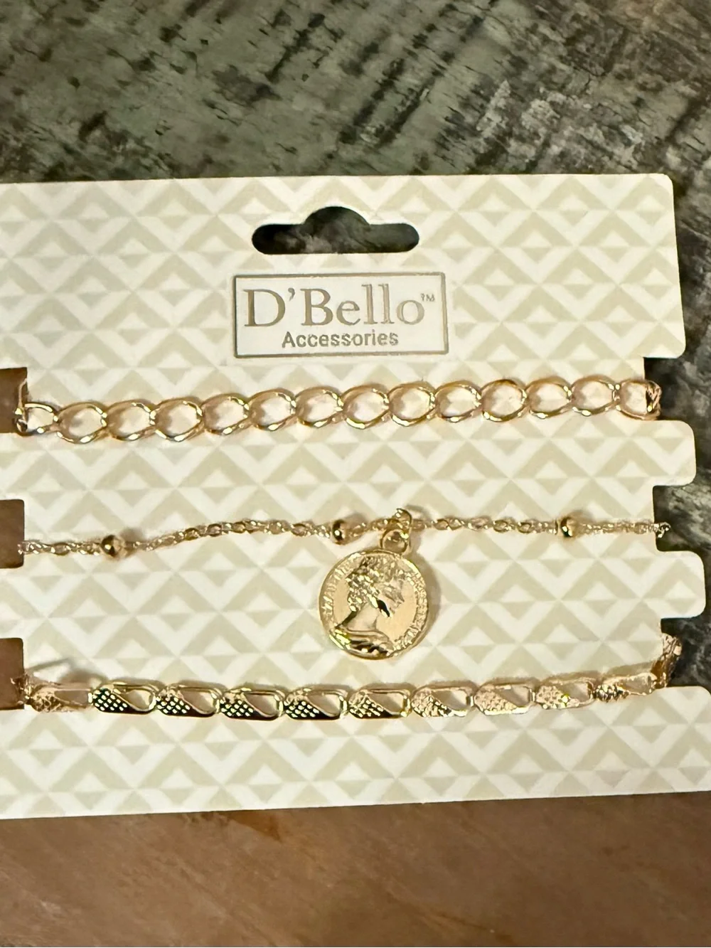 Set of 3 D’Bello packaged gold toned bracelets.